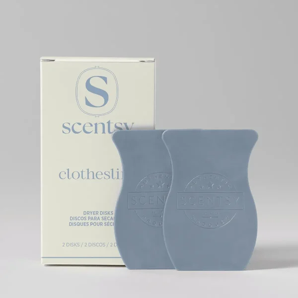 Two slate-blue waffle-textured dryer disks with embossed Scentsy branding, displayed next to cream packaging labelled Clothesline Dryer Disks