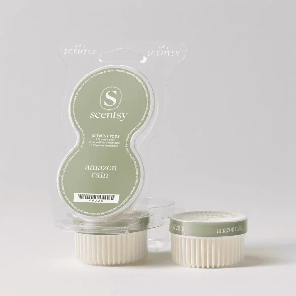 Two cream-coloured ridged wax pods with sage-green labels reading "amazon rain" beside clear blister packaging containing two Amazon Rain Scentsy Pods, displayed against a white background