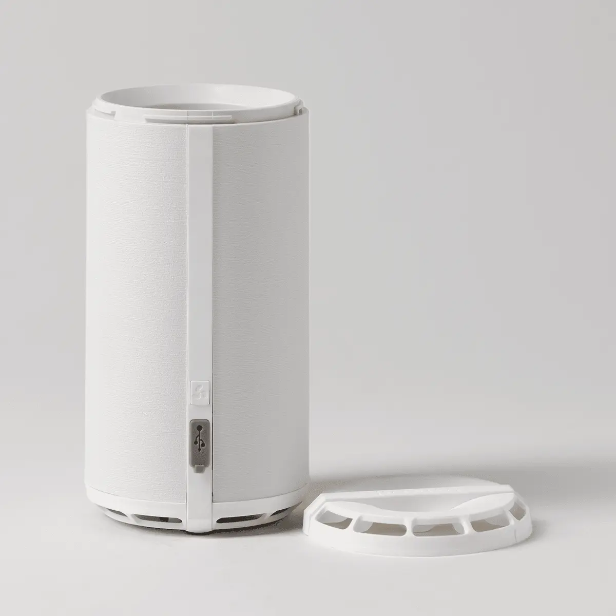 White cylindrical diffuser with a side-mounted power button and removable circular lid with vents, the Scentsy Air Go+