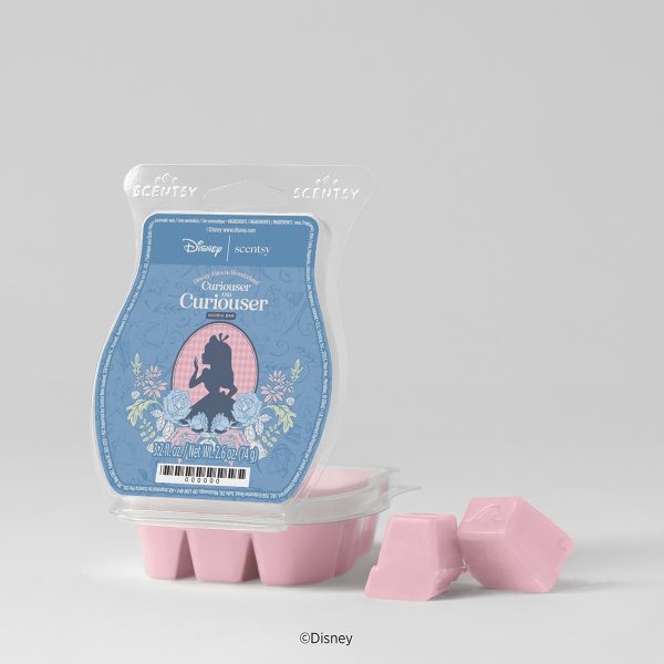 Pink wax cubes beside blue packaging showing an Alice silhouette framed by roses, the Disney Alice in Wonderland: Curiouser and Curiouser Scentsy Bar