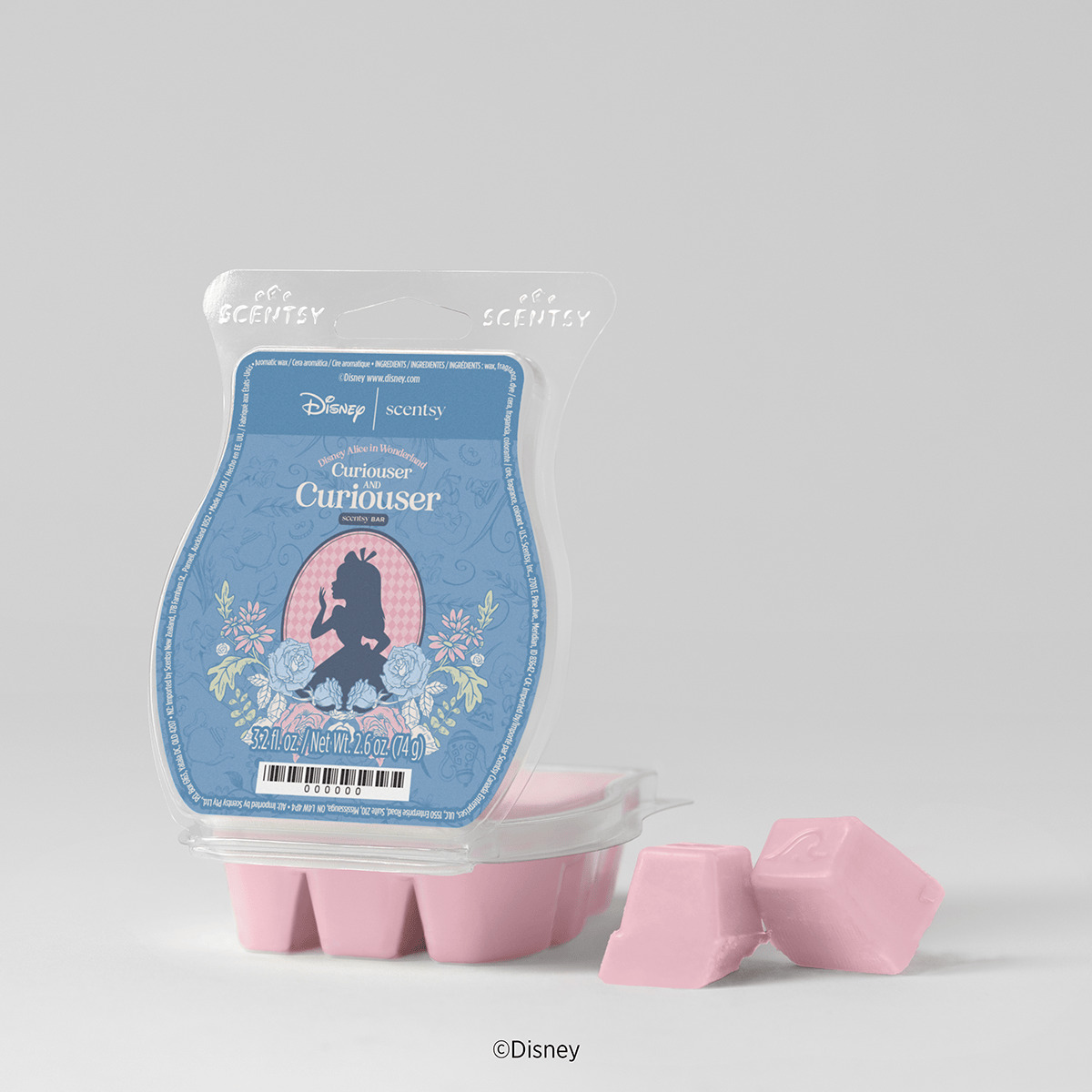 Pink wax cubes beside blue packaging showing an Alice silhouette framed by roses, the Disney Alice in Wonderland: Curiouser and Curiouser Scentsy Bar