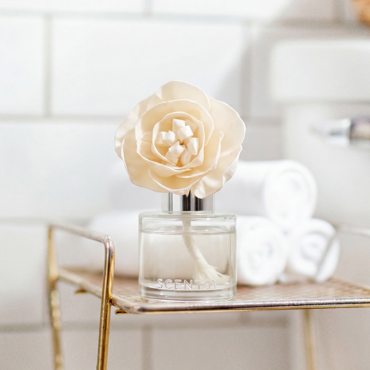 Cream-coloured rose bloom with layered petals and white stamen centre, displayed in a clear glass Scentsy diffuser bottle with chrome cap, the Amazon Rain - Buttercup Belle Fragrance Flower
