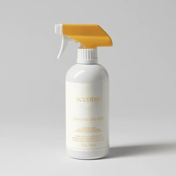 White spray bottle with gold trigger and pump top, displaying gold text reading "scentsy" and "Squeeze the Day Counter Clean" on the label, 16 fl oz