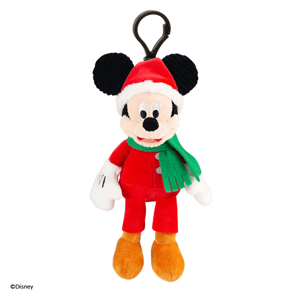 Plush Mickey Mouse character with black round ears, cream-coloured face, red Santa hat, red outfit with green scarf, white gloves, and orange shoes, attached to a black loop clip—the Mickey Mouse Holiday Scentsy Buddy Clip