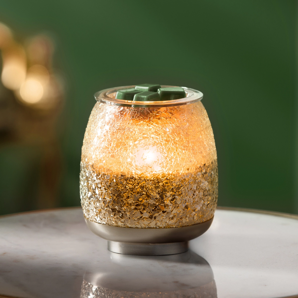 Textured gold and cream ceramic warmer with a metal base, topped with a green wax melt, the Glisten Scentsy Warmer