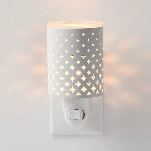 White ceramic cylinder with repeating four-pointed star cutout pattern casting warm light, with white base and toggle switch, the Light From Within Mini Scentsy Warmer