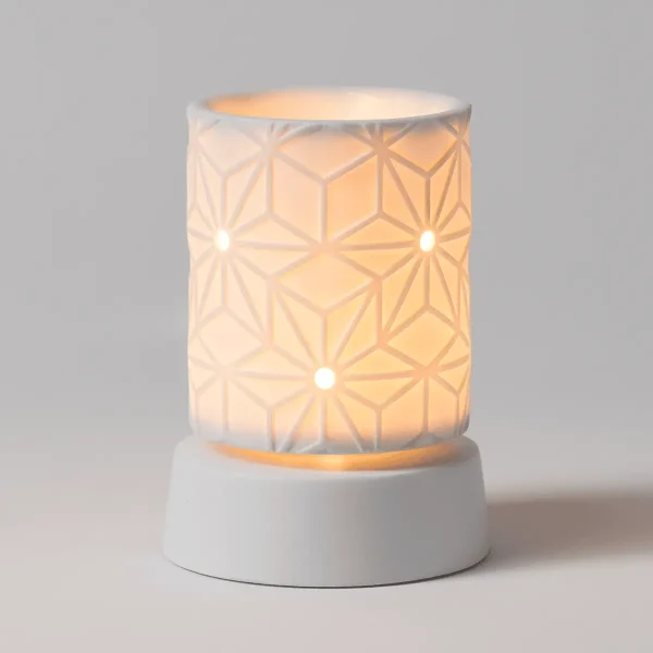 Cylindrical white ceramic warmer with geometric patterned cutouts casting warm light, featuring a solid white cylindrical base, the Salerno Mini Scentsy Warmer with Tabletop Base