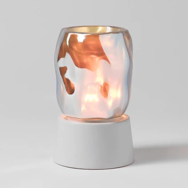 White ceramic tabletop base supporting a translucent iridescent glass warmer with orange and peach watercolour-like patterns, illuminated from within, the Bubbled - Iridescent Mini Scentsy Warmer with Tabletop Base