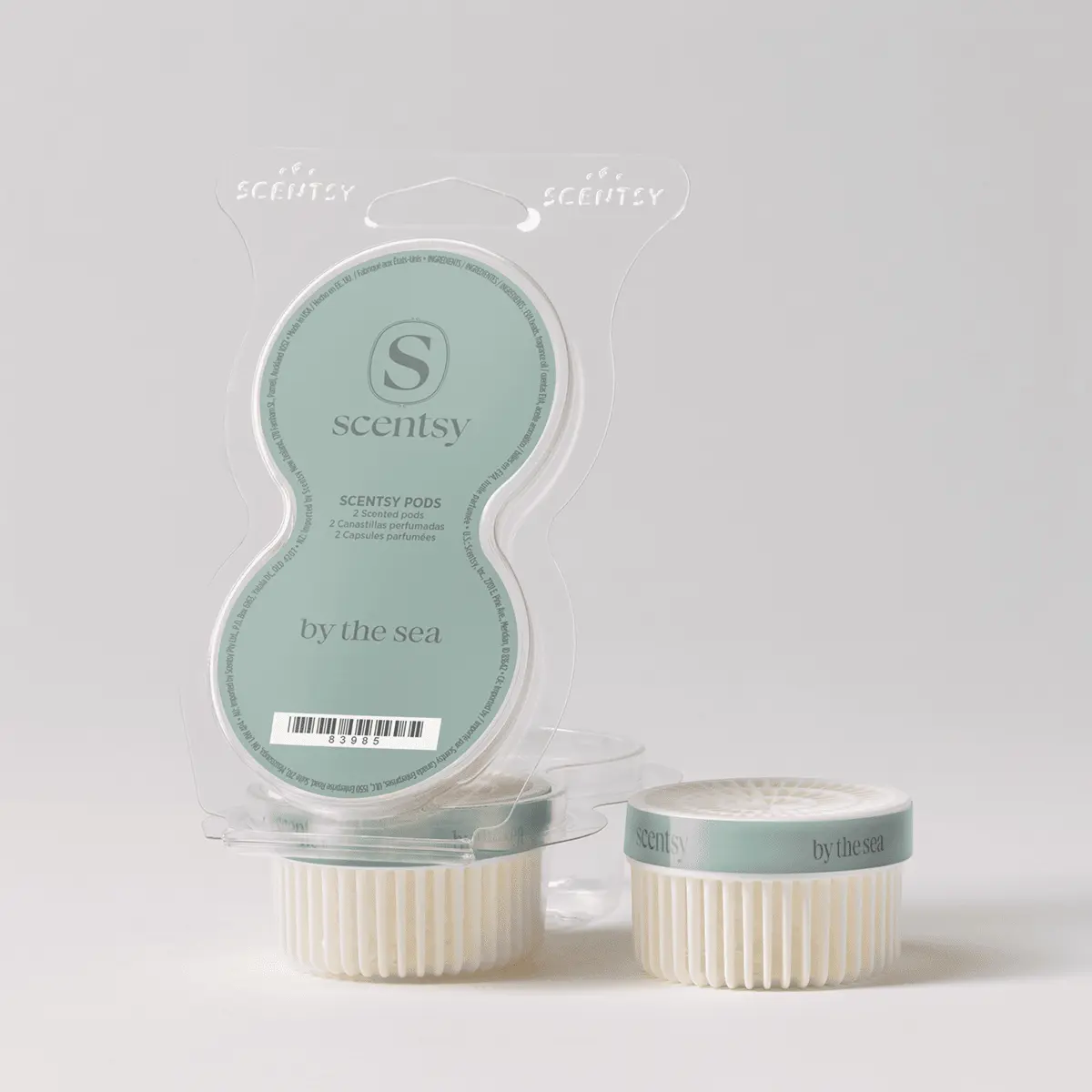 Sage green blister pack with two ribbed cream pods, one upright beside it, holding the By the Sea Scentsy Pods on a pale grey background