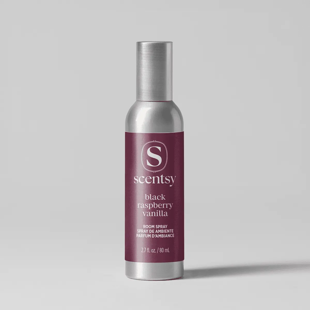 Silver cylindrical bottle with a brushed metal cap and deep burgundy label, the Black Raspberry Vanilla Room Spray, shown against a pale grey background