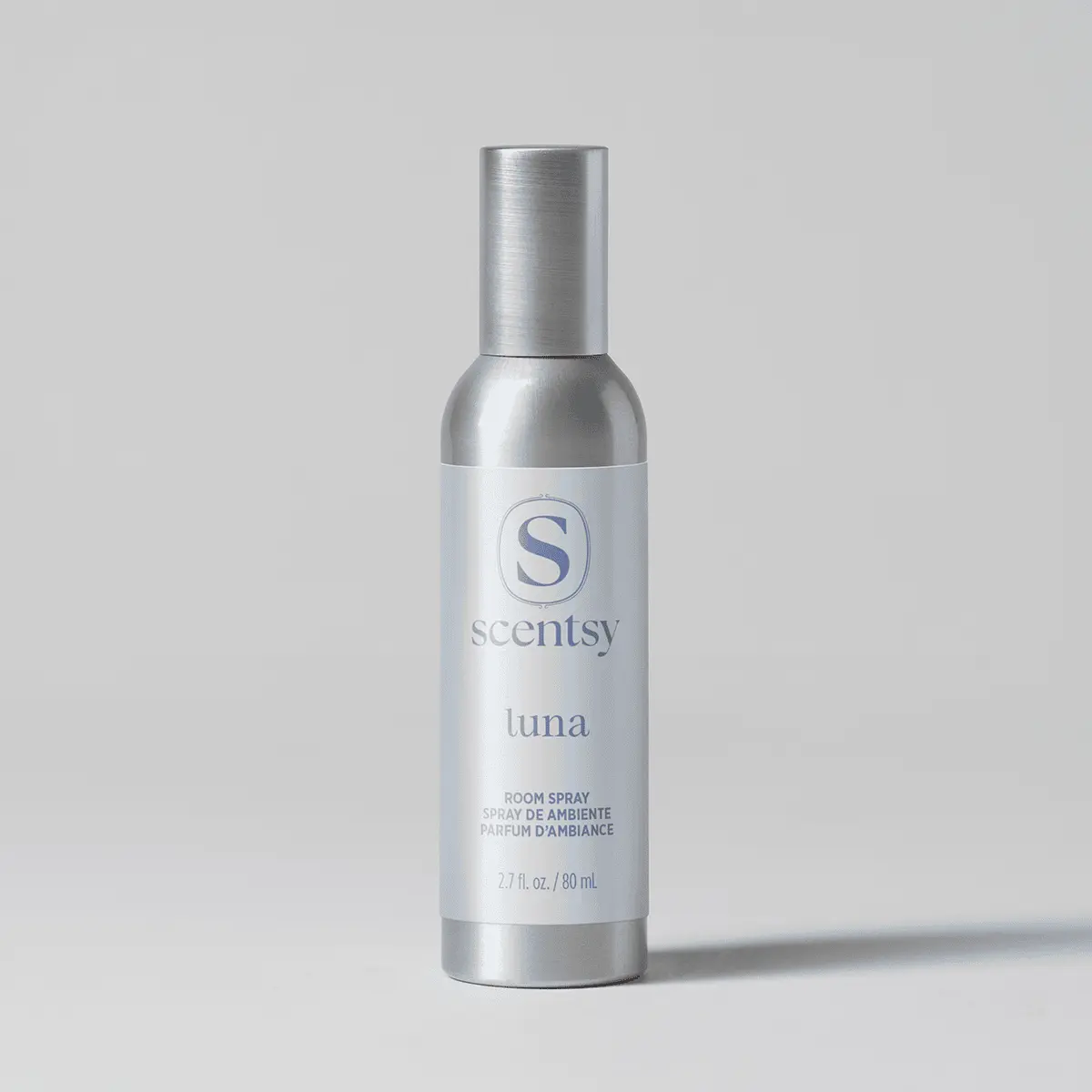 Brushed silver aluminium bottle with a pale blue-white label and matching cap, the Luna Room Spray, shown against a soft grey background