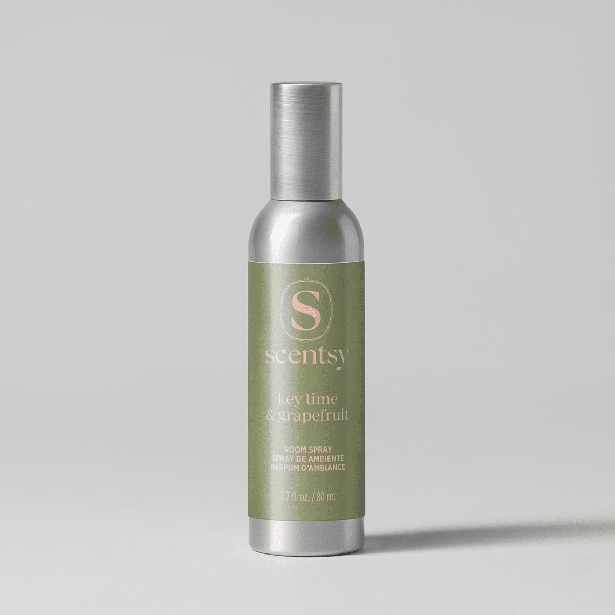 Brushed silver aerosol bottle with an olive green label and pink lettering, the Key Lime & Grapefruit Room Spray, on a pale grey background