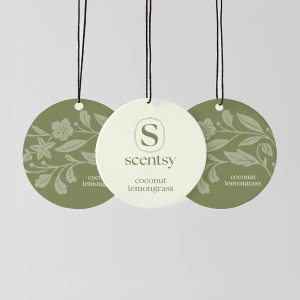 Three round Scent Circles hung from black strings—two sage-green with floral and leaf patterns, one cream with the Scentsy logo—the Coconut Lemongrass Scent Circle 3-pack