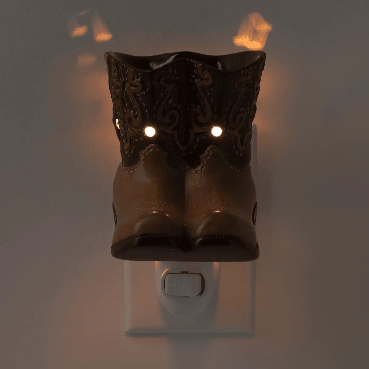 Black ceramic owl-shaped warmer with ornate feather detailing, glowing white eyes, and a white wall plug base, the Rodeo Mini Scentsy Warmer
