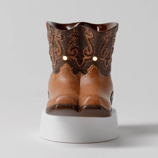 Cowboy boot-shaped warmer in tan and dark brown with ornamental scrollwork, two light holes, and a white cylindrical base, the Rodeo Mini Scentsy Warmer with Tabletop Base