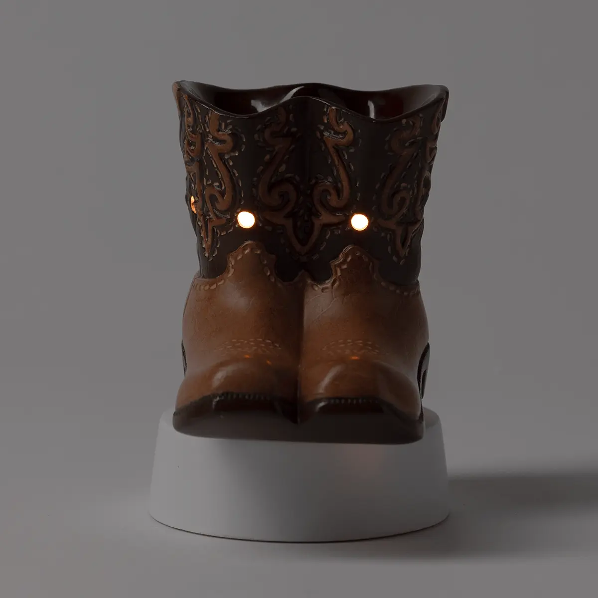 Decorative owl-shaped warmer in dark brown ceramic with ornate relief detailing, glowing amber eyes, and a white cylindrical base, the Rodeo Mini Scentsy Warmer