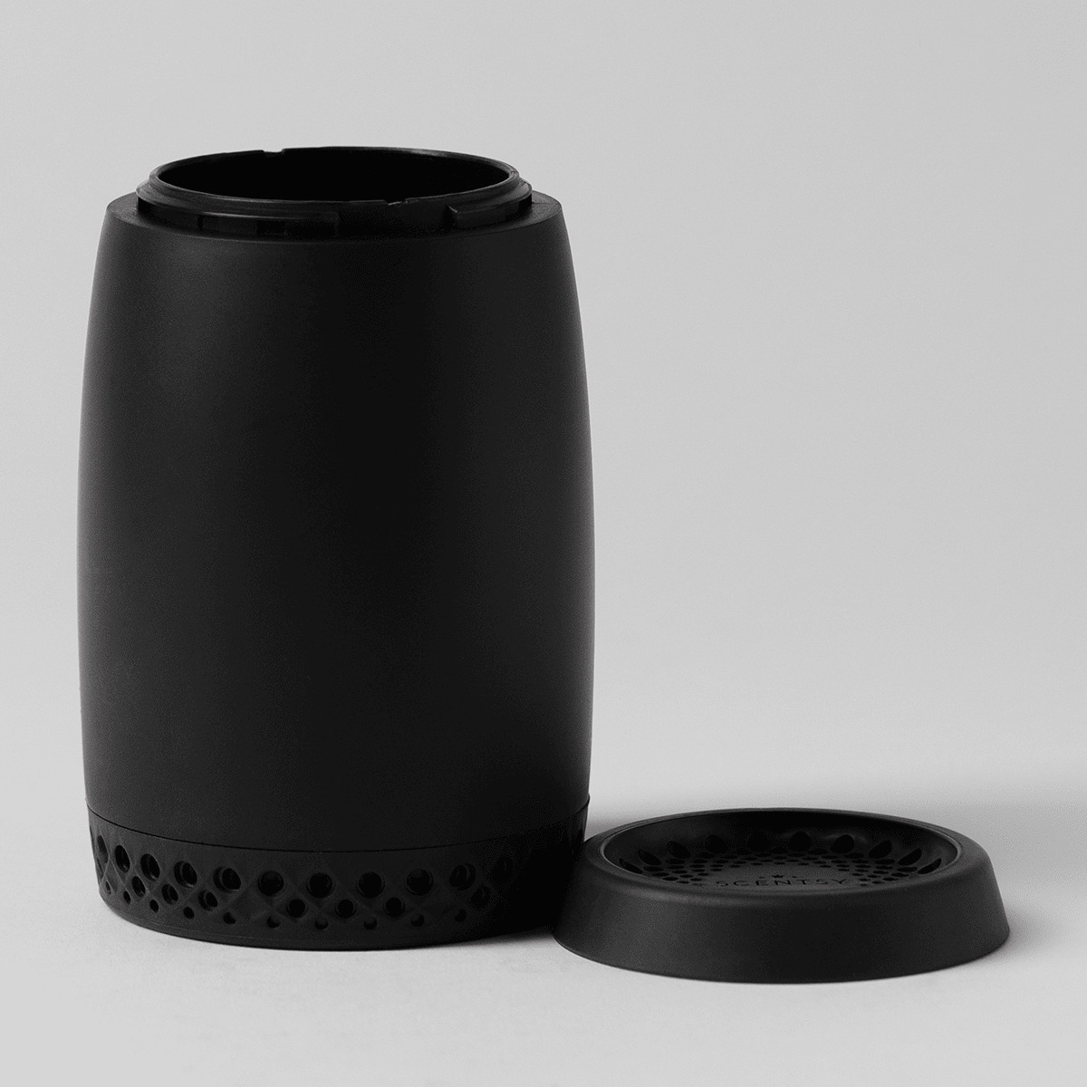 Matte black cylindrical Scentsy Air Go diffuser with perforated base detail and removable cap, shown with lid separated