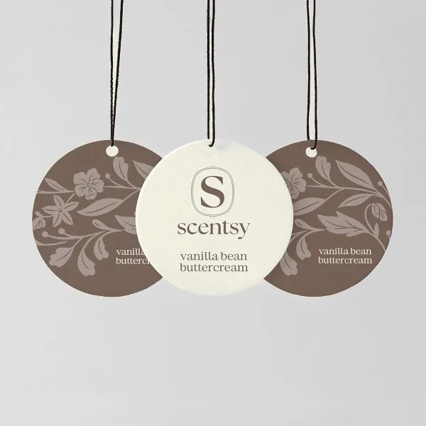 Three circular hanging Scent Circles with black cords and small white beads: cream centre disc with Scentsy logo and "vanilla bean buttercream" text, flanked by two taupe discs with floral damask pattern, for the Vanilla Bean Buttercream Scent Circle 3-pack