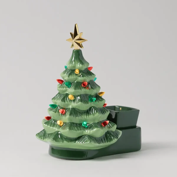 Ceramic Christmas tree warmer in pale green with textured branches, decorated with red, gold, and turquoise ornaments and topped with a gold star, with a dark green wax dish beside it, the Merry Little Christmas Scentsy Warmer