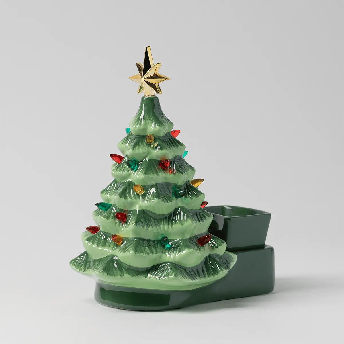 Ceramic Christmas tree warmer in pale green with textured branches, multicoloured ornaments, a gold star topper, and dark green base with upper heating dish, the Merry Little Christmas Scentsy Warmer