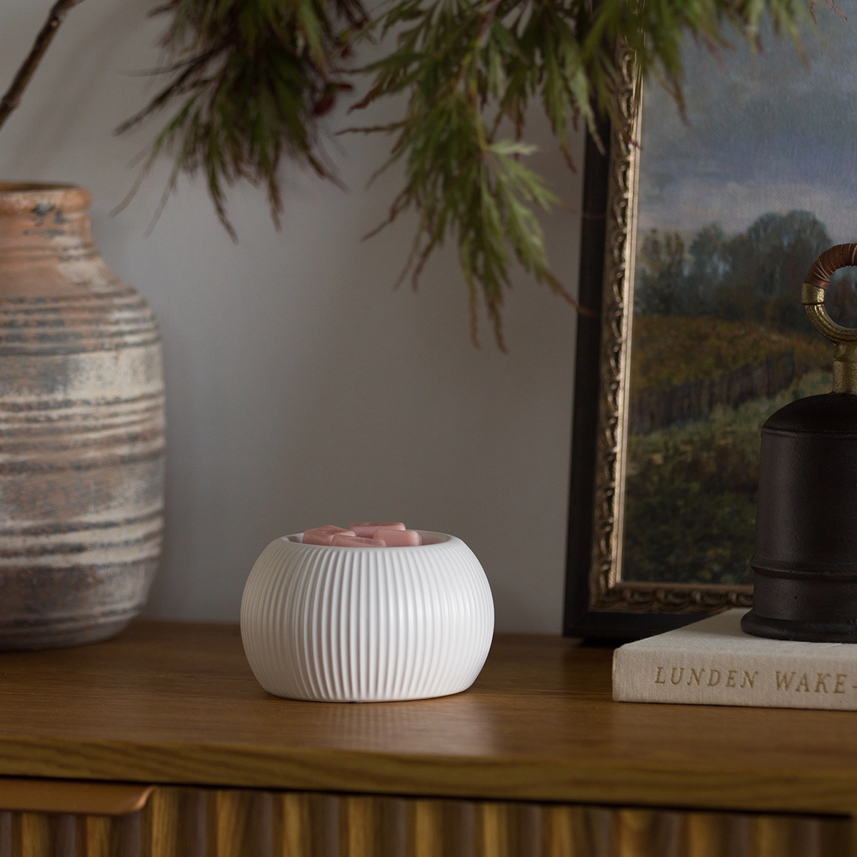 White ceramic warmer with a rounded, ribbed silhouette and pink wax visible in the opening, the White Fluted Scentsy Warmer