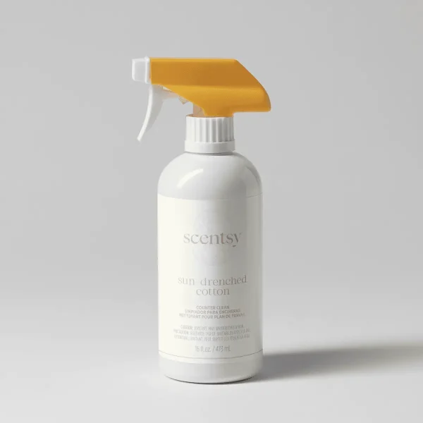 White spray bottle with gold trigger and white ribbed collar, labelled Sun-Drenched Cotton Counter Clean, containing 16 fl oz of cleaning product