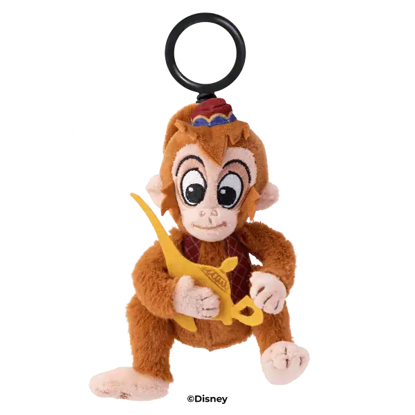 Brown plush monkey with large expressive eyes, holding a yellow banana, wearing a red hat with a blue accent, attached to a black ring clip—the Abu Scentsy Buddy Clip