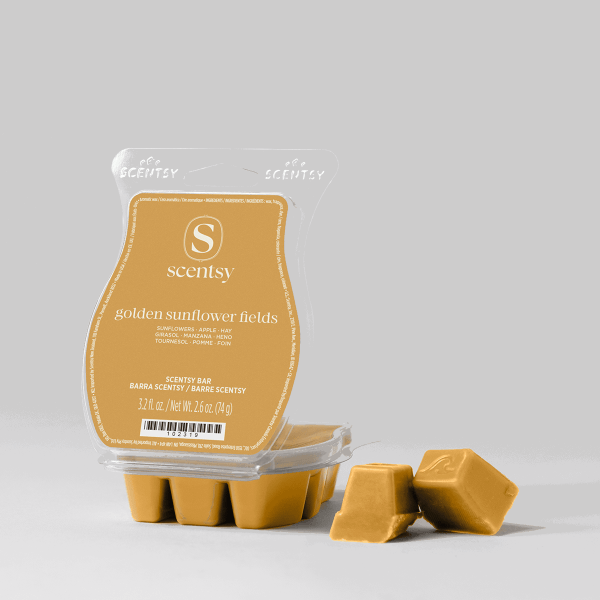 Golden mustard-coloured Scentsy Bar wax in a clear clamshell package with gold label showing sunflower, apple, hay and other notes, displayed with individual wax cubes beside the Golden Sunflower Fields Scentsy Bar packaging