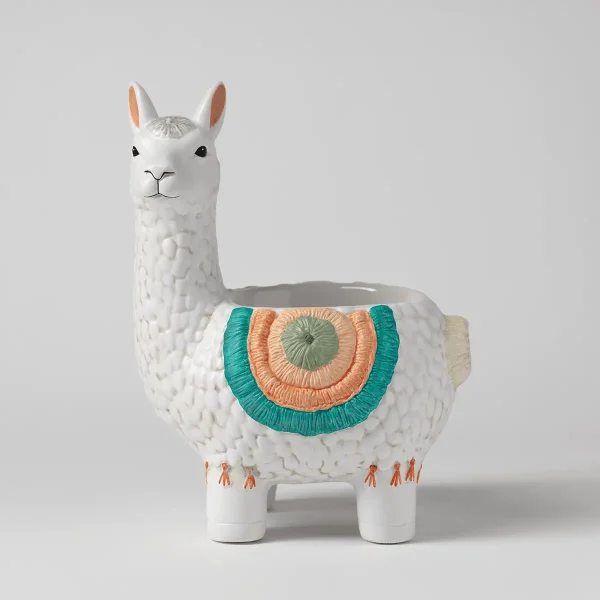 White ceramic llama-shaped warmer with textured wool detail, peach inner ears, black eyes and nose, a colourful geometric blanket in teal, orange and sage green across its back, and small orange figure details on its legs, the Llama Scentsy Warmer