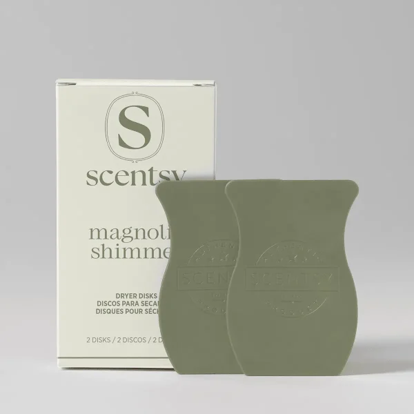 Two sage-green scented dryer disks with embossed Scentsy branding, displayed next to their cream packaging box labelled Magnolia Shimmer Dryer Disks
