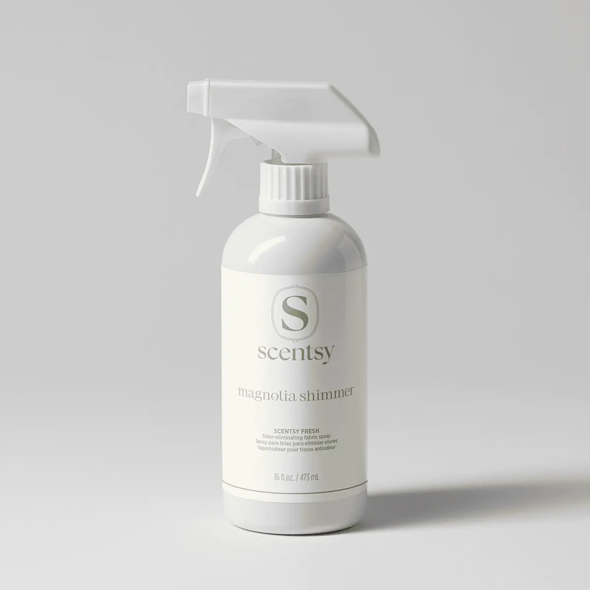 White spray bottle with trigger dispenser, printed with the Scentsy logo and "magnolia shimmer" text, labeled Magnolia Shimmer Scentsy Fresh fabric spray, 15 fl oz