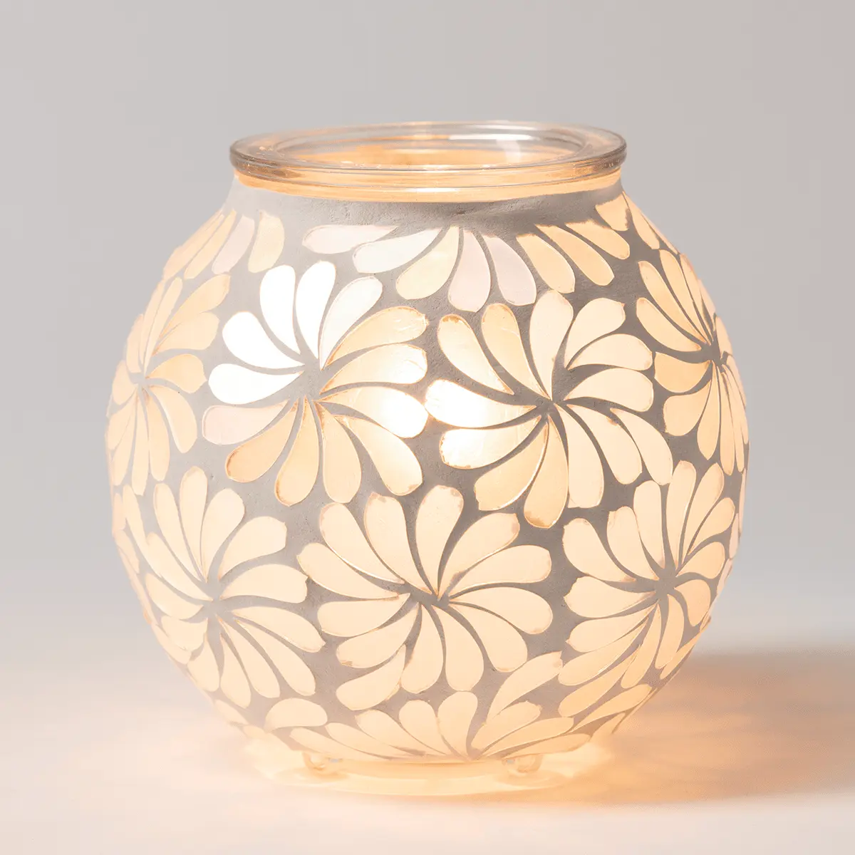 Rounded glass warmer with an all-over daisy flower pattern in cream and white tones that glow warmly when lit, the Sky Blossom Scentsy Warmer