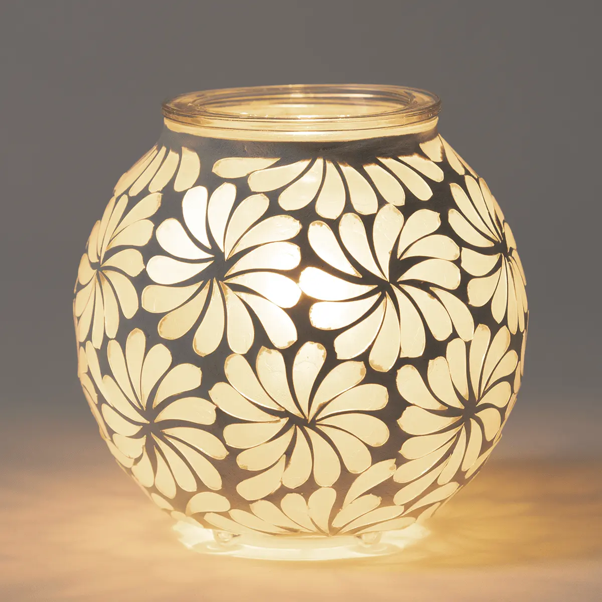 Rounded glass warmer with cream-coloured floral cutouts casting warm light, the Sky Blossom Scentsy Warmer