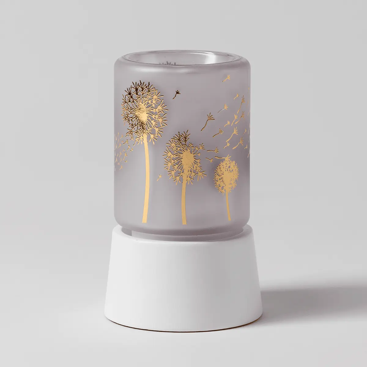 Frosted grey cylindrical warmer with gold dandelion and seedhead design, white ceramic tabletop base, the Wishbloom Mini Scentsy Warmer