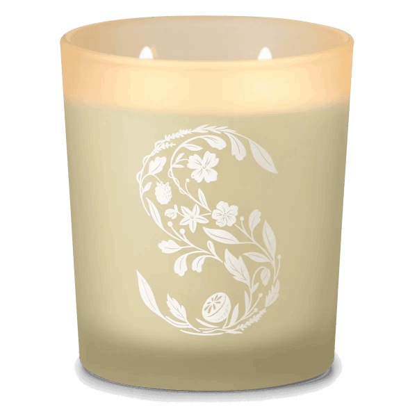 Cream-coloured two-wick candle with white ornamental floral and leaf design featuring a decorative letter S, the Petals & Peaches Scentsy Candle