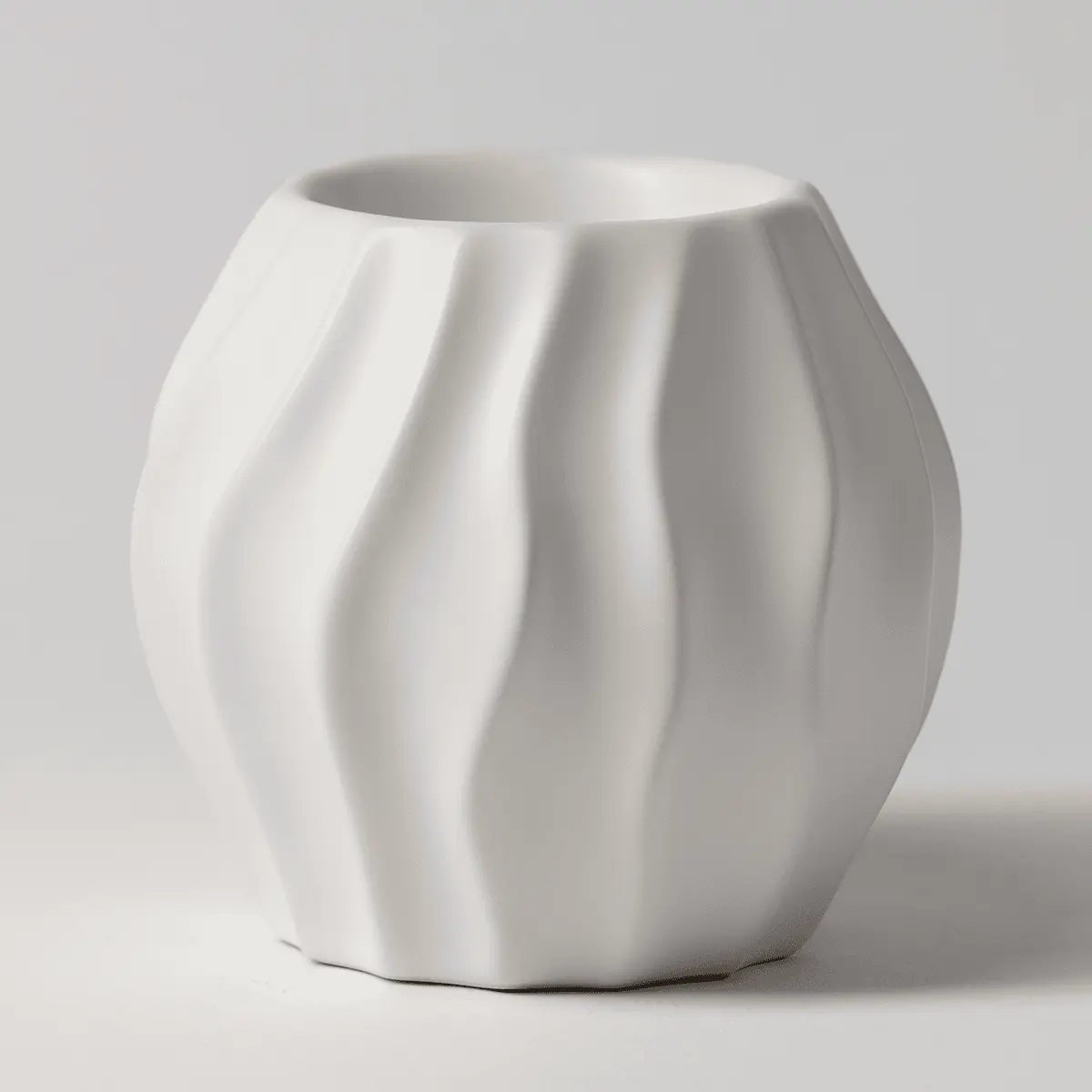 White ceramic Scentsy warmer with a ribbed, wave-like texture curving around its rounded body, the Cascade Scentsy Warmer