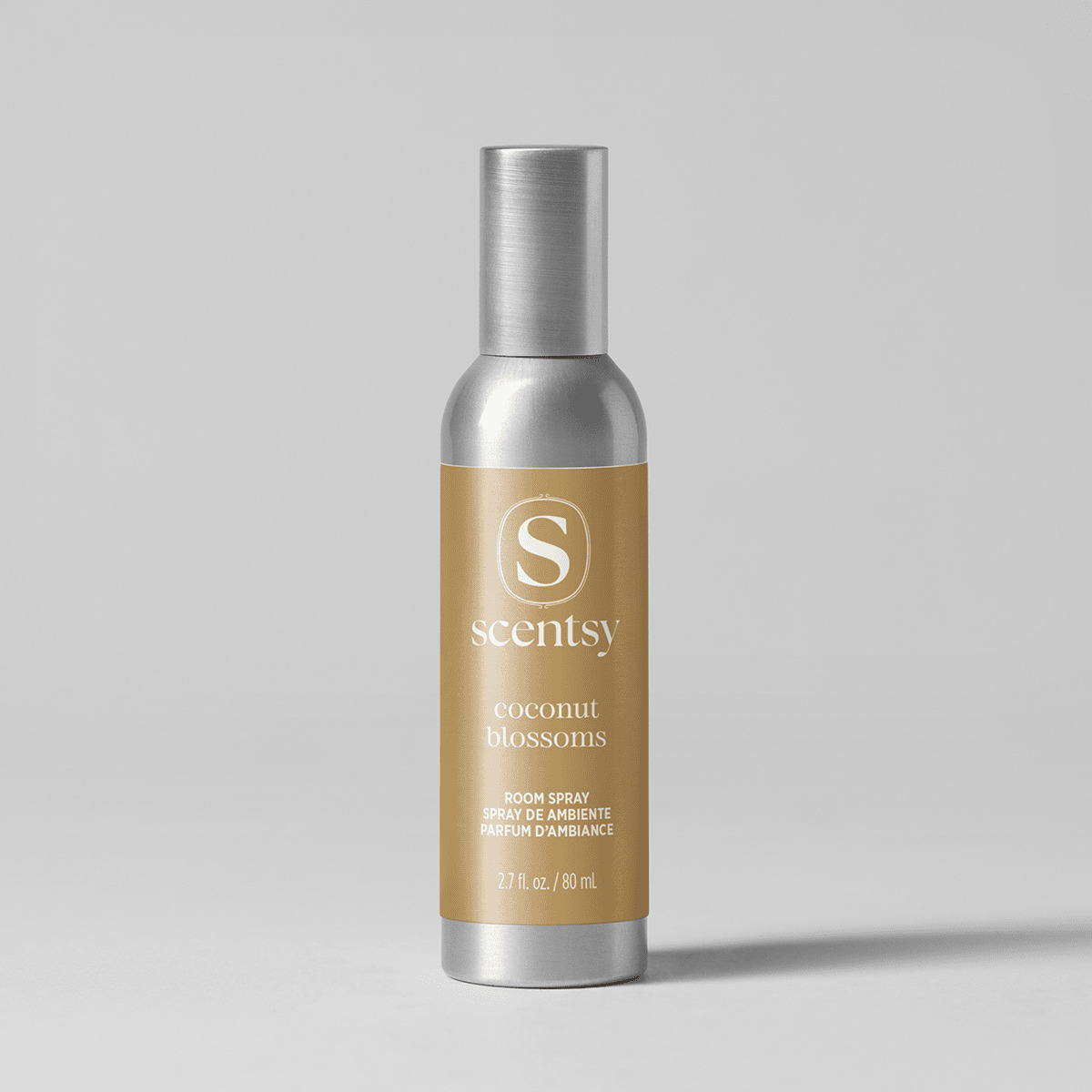 Slim silver aluminium bottle with a brushed cap and tan label, the Coconut Blossoms Room Spray, shown against a pale grey background