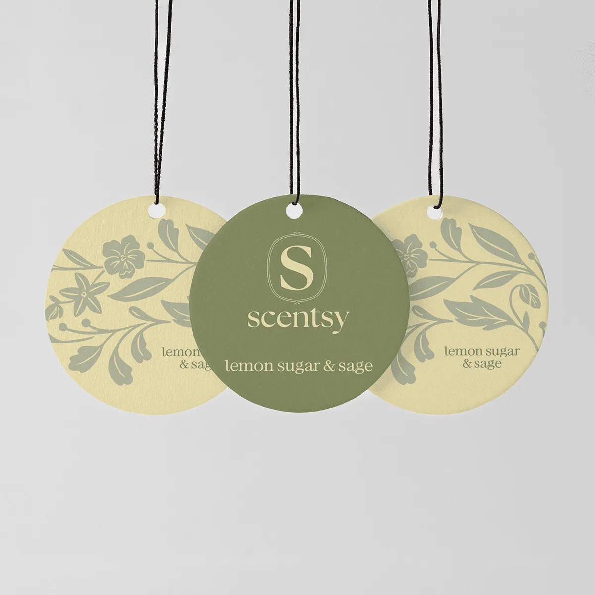 Lemon Sugar & Sage Scent Circle 3-pack - Three circular hanging Scent Circles with black cords: two pale yellow with grey botanical motifs, one sage green with the Scentsy logo, all printed with "lemon sugar & sage" text, the Lemon Sugar & Sage Scent Circle 3-pack