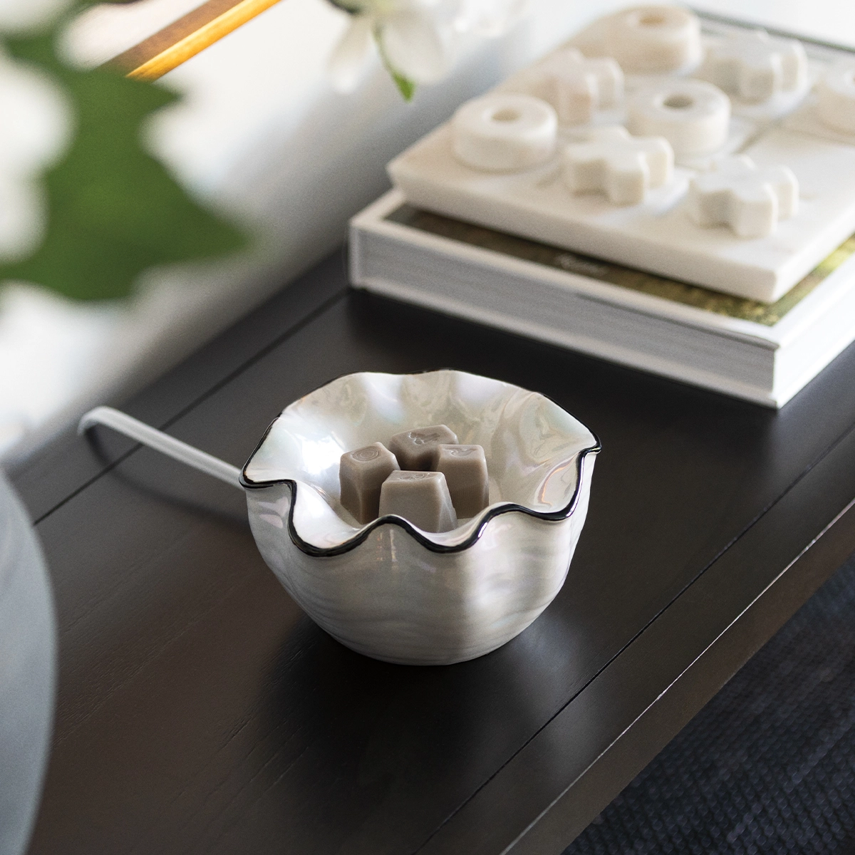 White ceramic warmer with a ruffled rim and black trim, holding tan wax cubes, the Lustra Scentsy Warmer