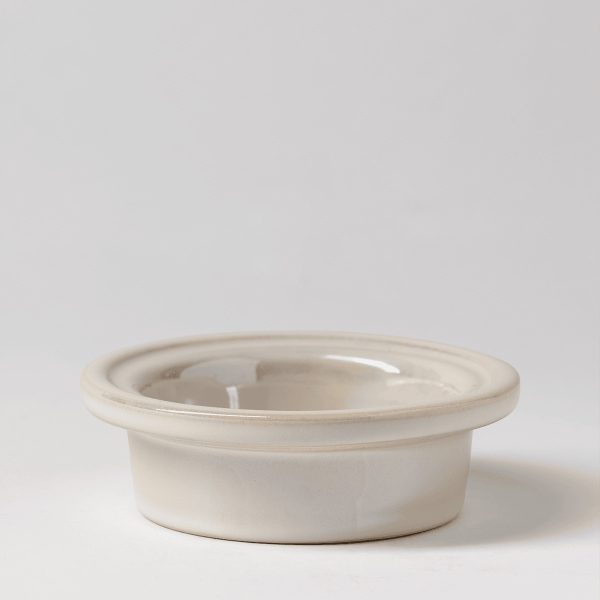 Cream ceramic warmer dish with a wide rim and central well for wax, the Dreamer's Bow Replacement Dish