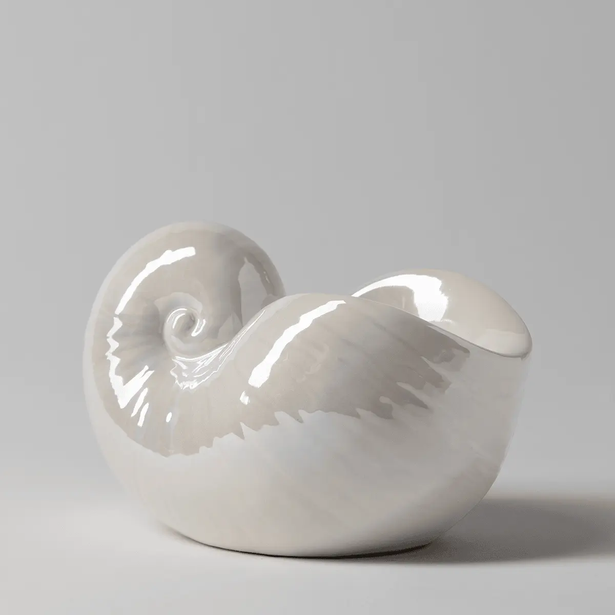 Glossy white ceramic warmer shaped like a nautilus shell with detailed ridging and spiral design, the Nautilus Scentsy Warmer