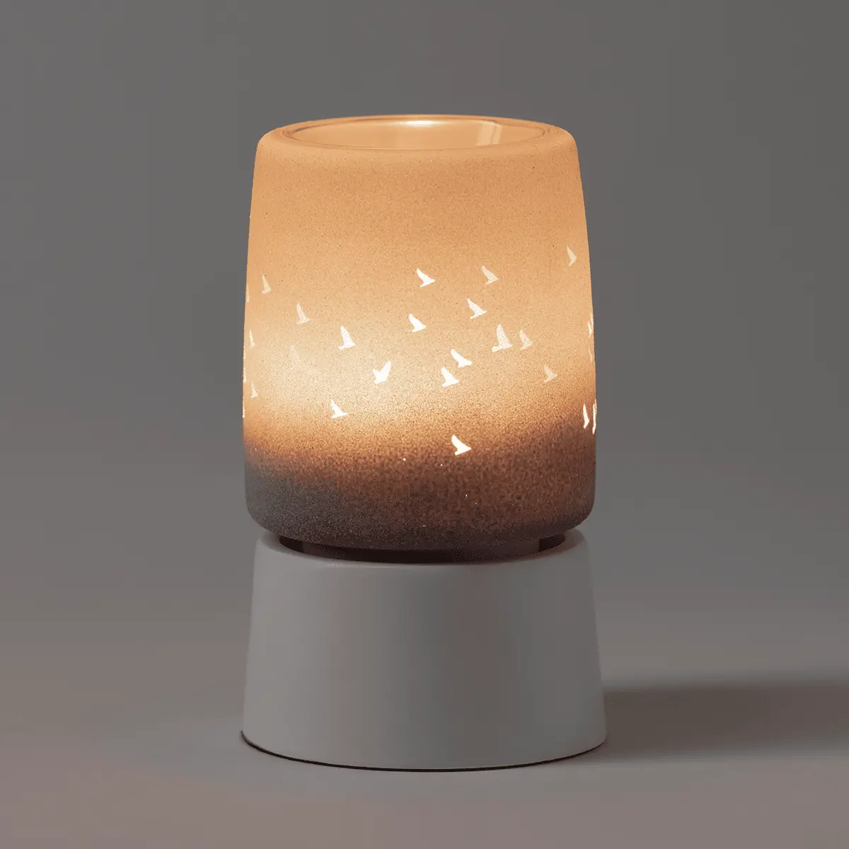 Ceramic mini warmer with a ombré glaze fading from cream to brown, white cutout bird silhouettes in flight, and a white cylindrical tabletop base, the Waves & Wings Mini Scentsy Warmer