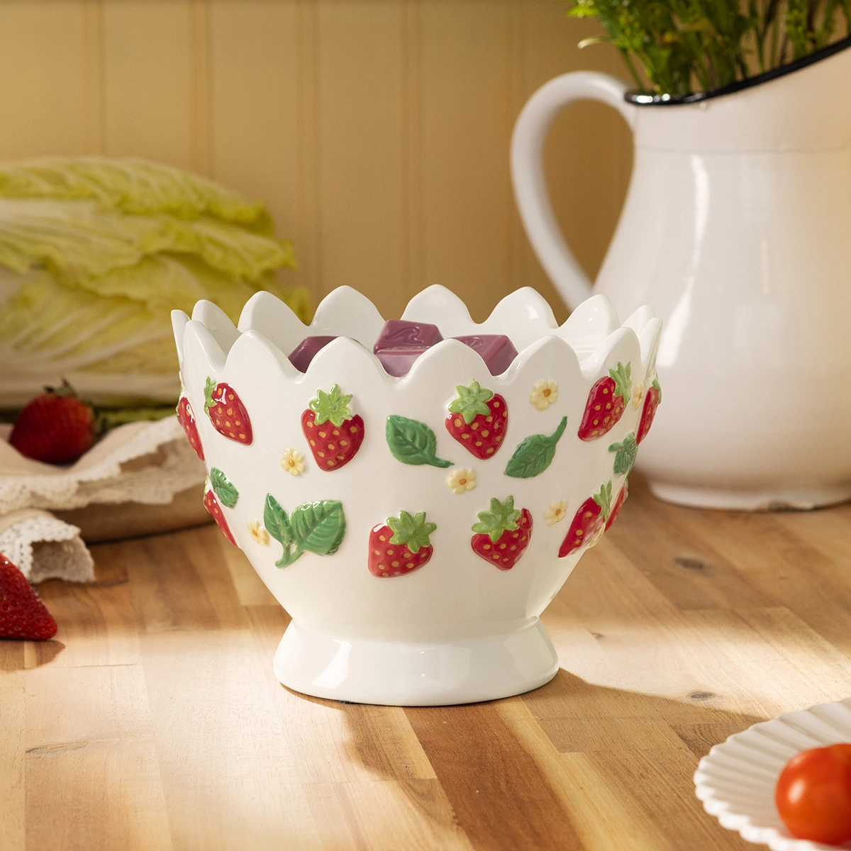 White ceramic warmer with a scalloped crown rim and pedestal base, decorated with red strawberries, green leaves, and small yellow flowers, the Strawberry Garden Scentsy Warmer