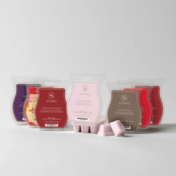 Collection of Scentsy Bars in clear plastic clamshell packaging arranged in a display, including purple, red, pink and brown coloured bars, with loose pink wax cubes in front, the August Bring Back My Bar Bundle