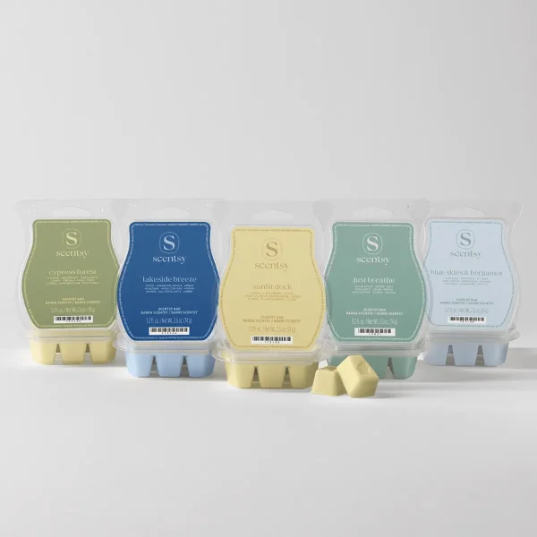 Five Scentsy Bars in assorted colours—olive green, blue, pale yellow, sage green, and pale blue—displayed in clear plastic clamshell packaging with labels, the Cosy Cabin Scentsy Bar 5-pack, with two wax bars shown in front
