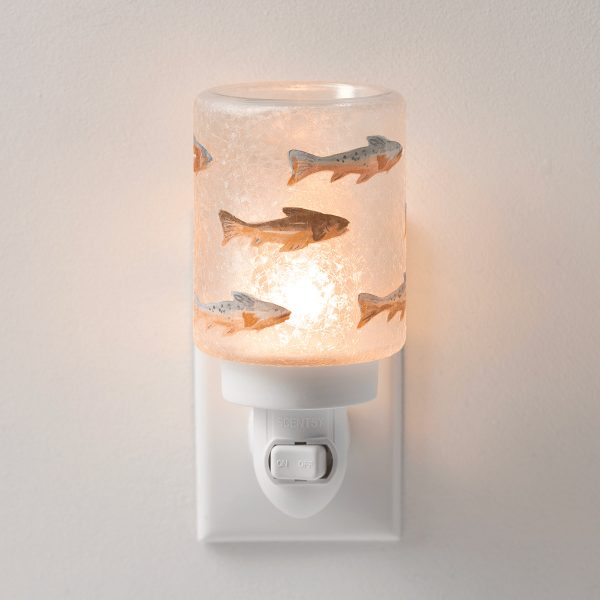 Wall-plug mini warmer with a textured pale pink glass shade decorated with swimming fish in orange, grey and brown tones, the Silverfin Mini Scentsy Warmer, glowing warmly against a neutral background