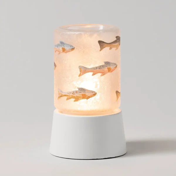 Translucent peach-toned cylindrical warmer with painted fish in grey, orange and brown tones, seated on a white ceramic base, the Silverfin Mini Scentsy Warmer with Tabletop Base, glowing warmly from within