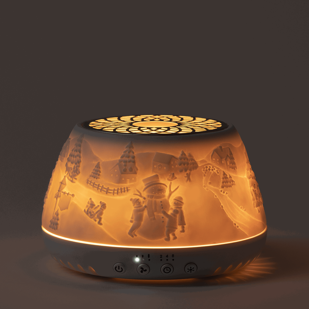 Scentsy Air Quad diffuser with winter scene cutouts casting warm light, black base with control buttons, and geometric pattern on top