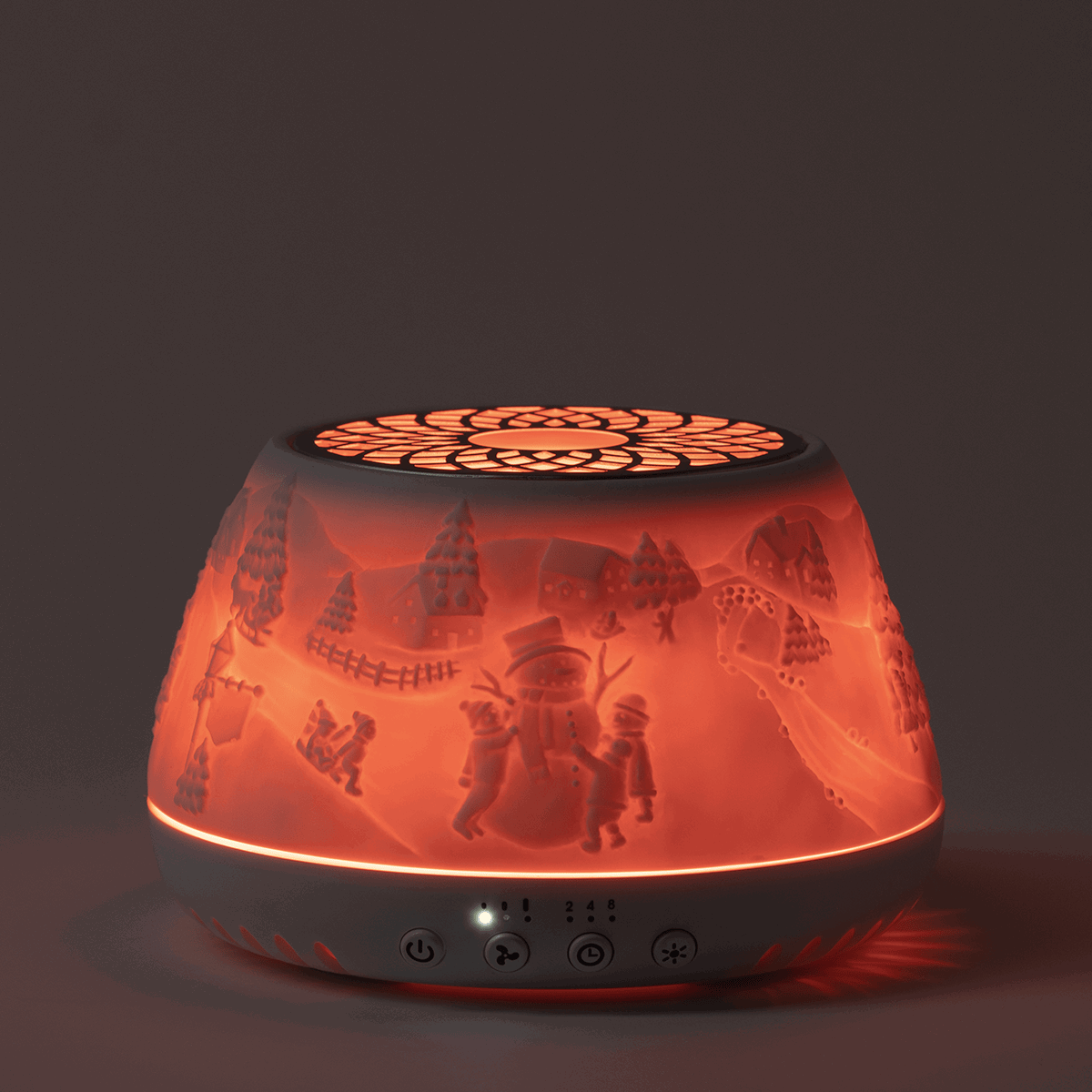 Red glowing diffuser with holiday scene silhouettes including trees, snowman and children, illuminated from within, the Scentsy Air Quad - Icicle Lan