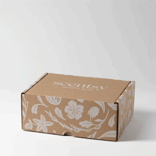 A kraft cardboard Scentsy Whiff Box with a white floral print and the Scentsy Whiff Box logo on the lid, photographed closed on a plain studio background